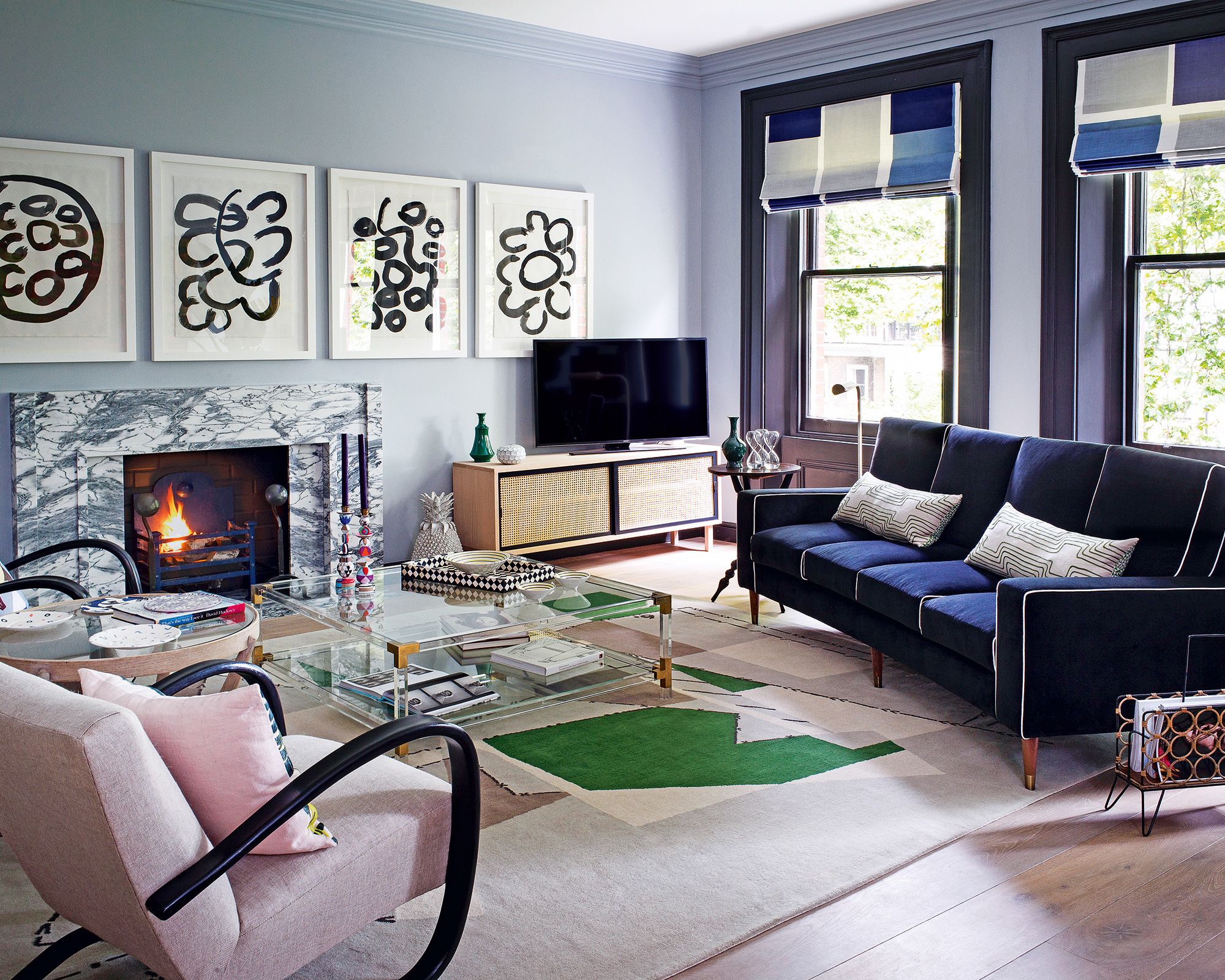 An example of living room trends showing a purple color scheme with graphic black and white wall art.