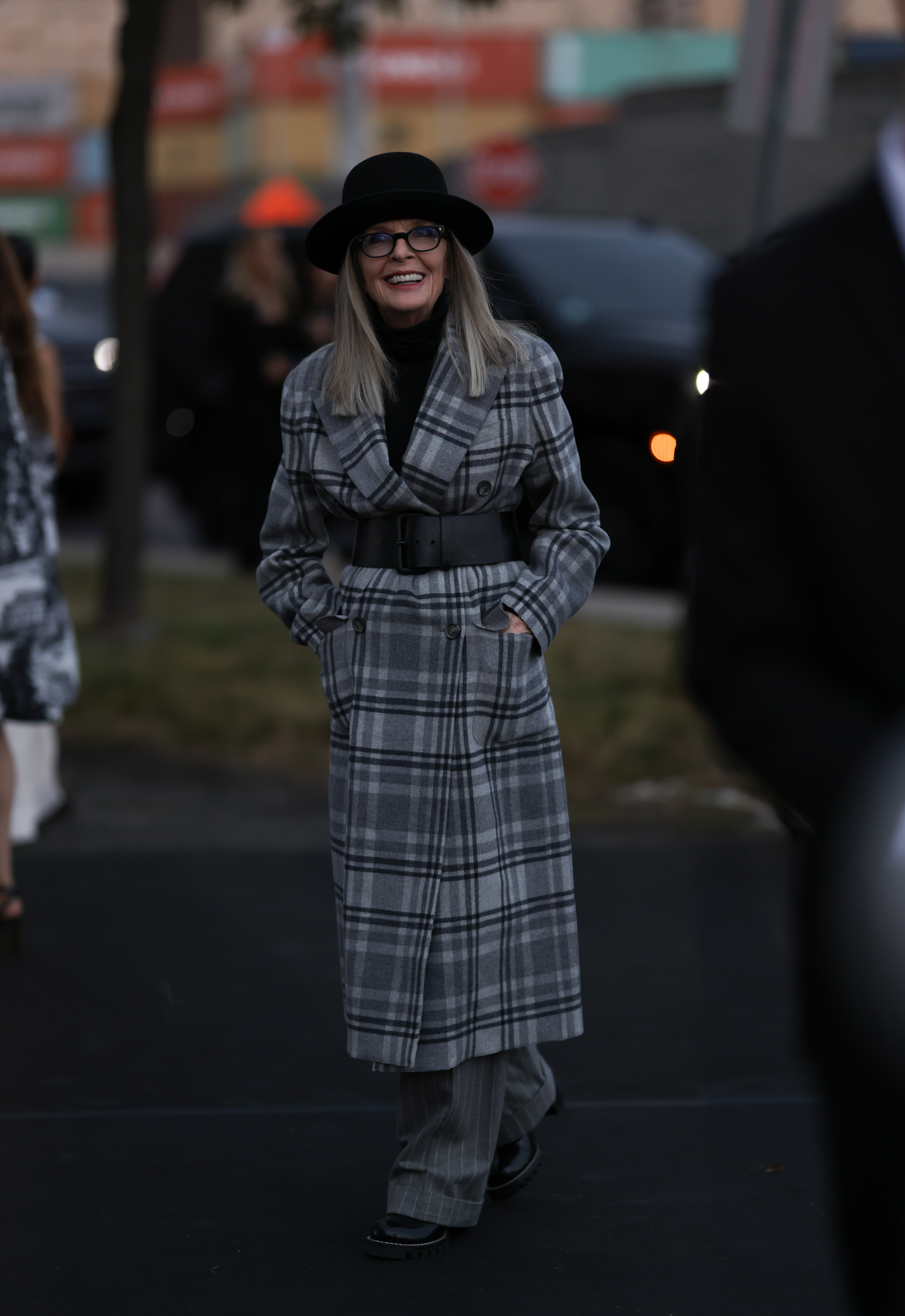 NEW YORK, NEW YORK - SEPTEMBER 08: Diane Keaton is seen outside Ralph Lauren show wearing black hat, grey checkered coat with black leather waist belt, grey striped pants and black boots on September 08, 2023 in New York City. (Photo by Jeremy Moeller/Getty Images)