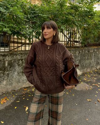 Julie Sergent Ferreri in brown jumper and tartan trousers