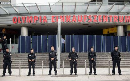 Police stand in front of the Munich shopping mall where a mass shooting occurred