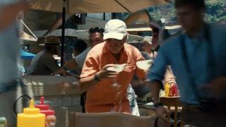 Jimmy Buffet trying to protect two margaritas in a fleeing crowd in Jurassic World.