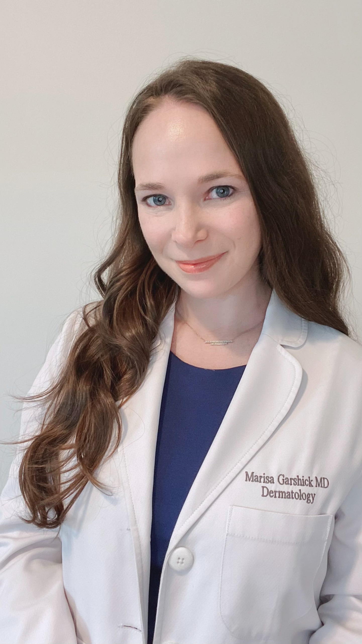 a white woman with light brown hair in a white lab coat