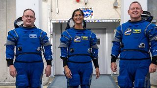 three astronauts standing in spacesuits