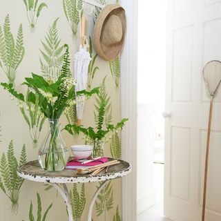 hallway with leafy wallpaper and flower vase