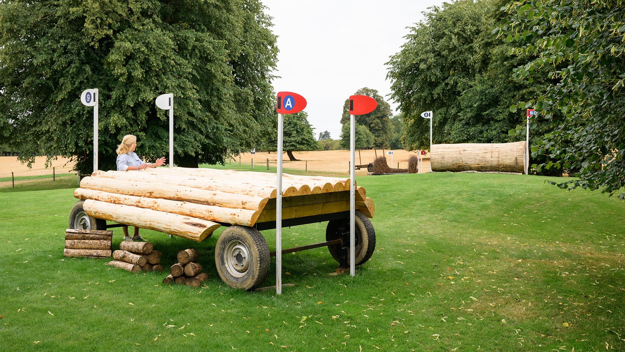 A trailer fence with event rider Tina Cook leaning on it, on the Burghley cross-country course 2026