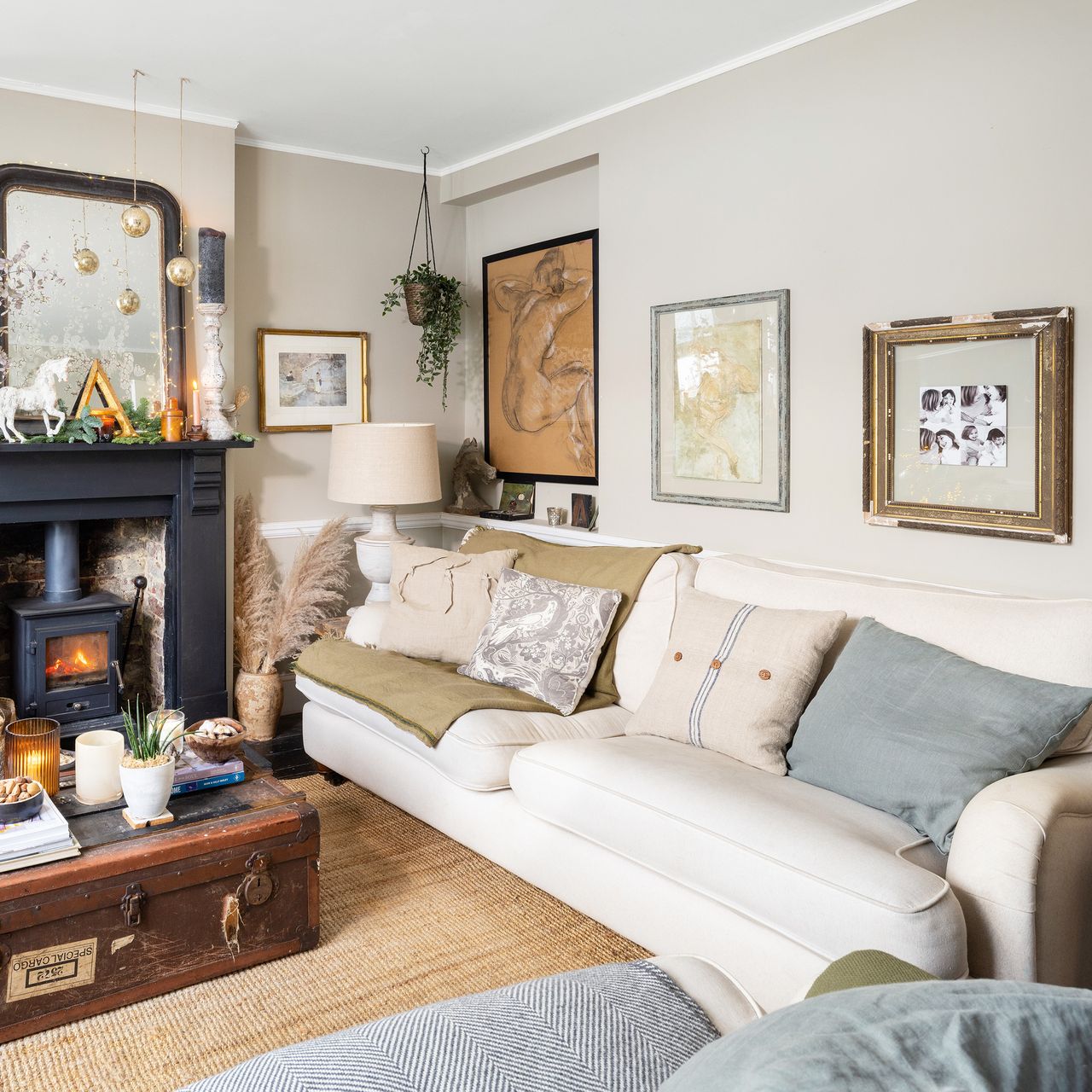 family living room with woodburner and fireplace with a cosy pale sofa