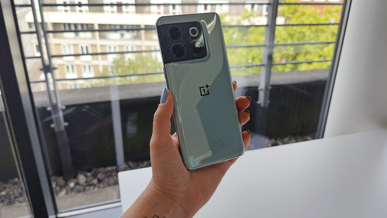 OnePlus 10T review: woman holding a phone in front of a window