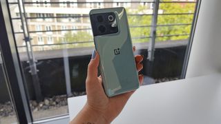 OnePlus 10T review: woman holding a phone in front of a window