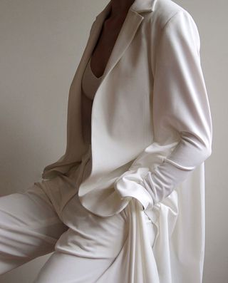 Female model wearing baggy white suit