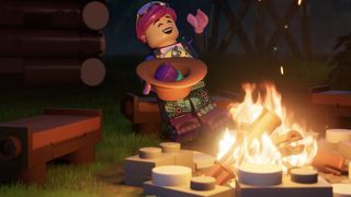 Un personnage Lego assis près d'un feu de camp. Il rit et rejette la tête en arrière, tout en tenant un bol de nourriture.