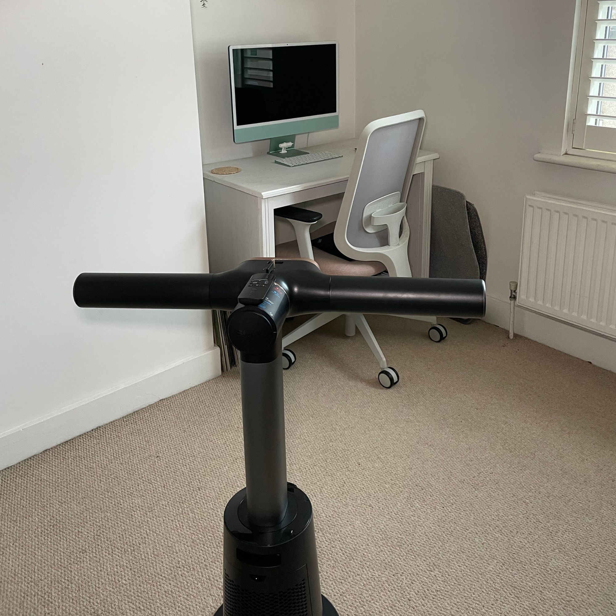 Shark TurboBlade Cool + Heat TH200UK sitting in front of a white wooden desk and desk chair, with a green computer sitting on it