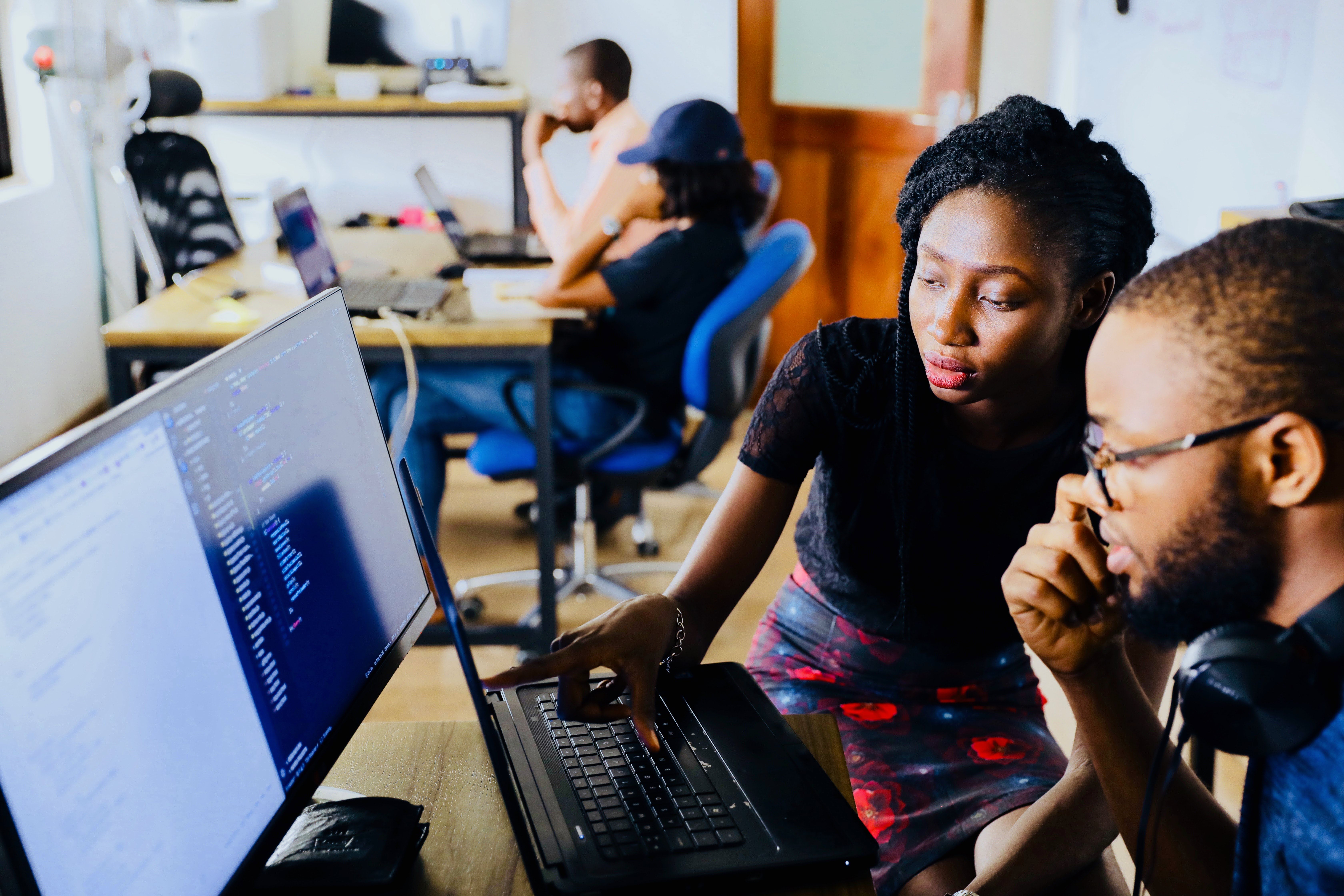 Two people working on computers in an office