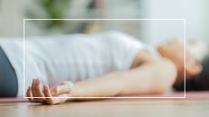 woman lying on floor in yoga nidra pose