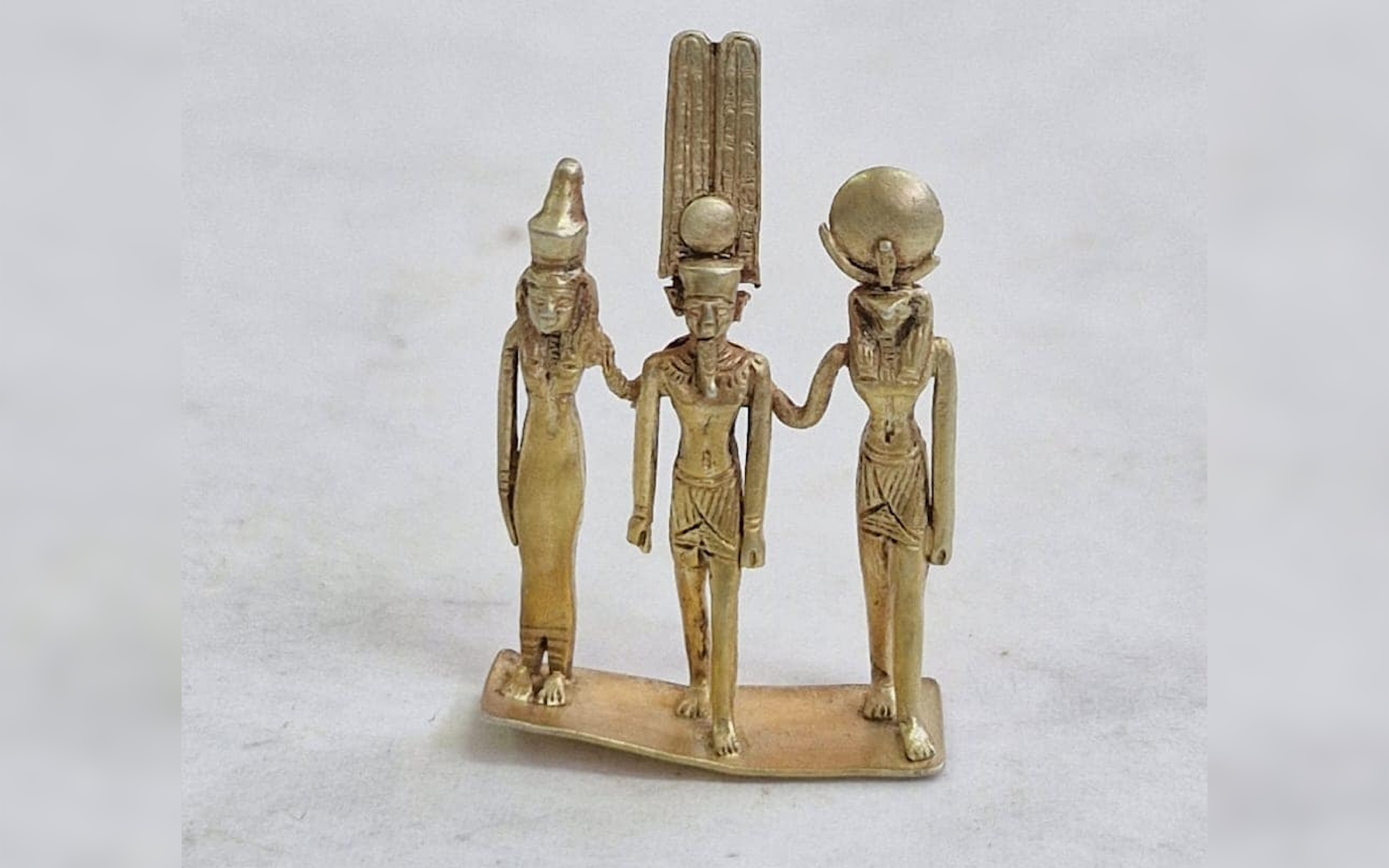 A gold statuette of three figures