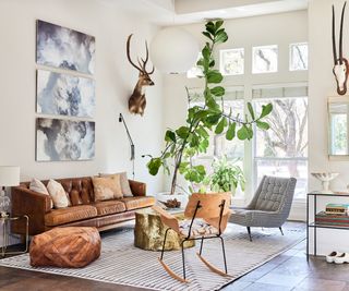 living room with white walls and retro leather couch plus tall plant and rocking chair