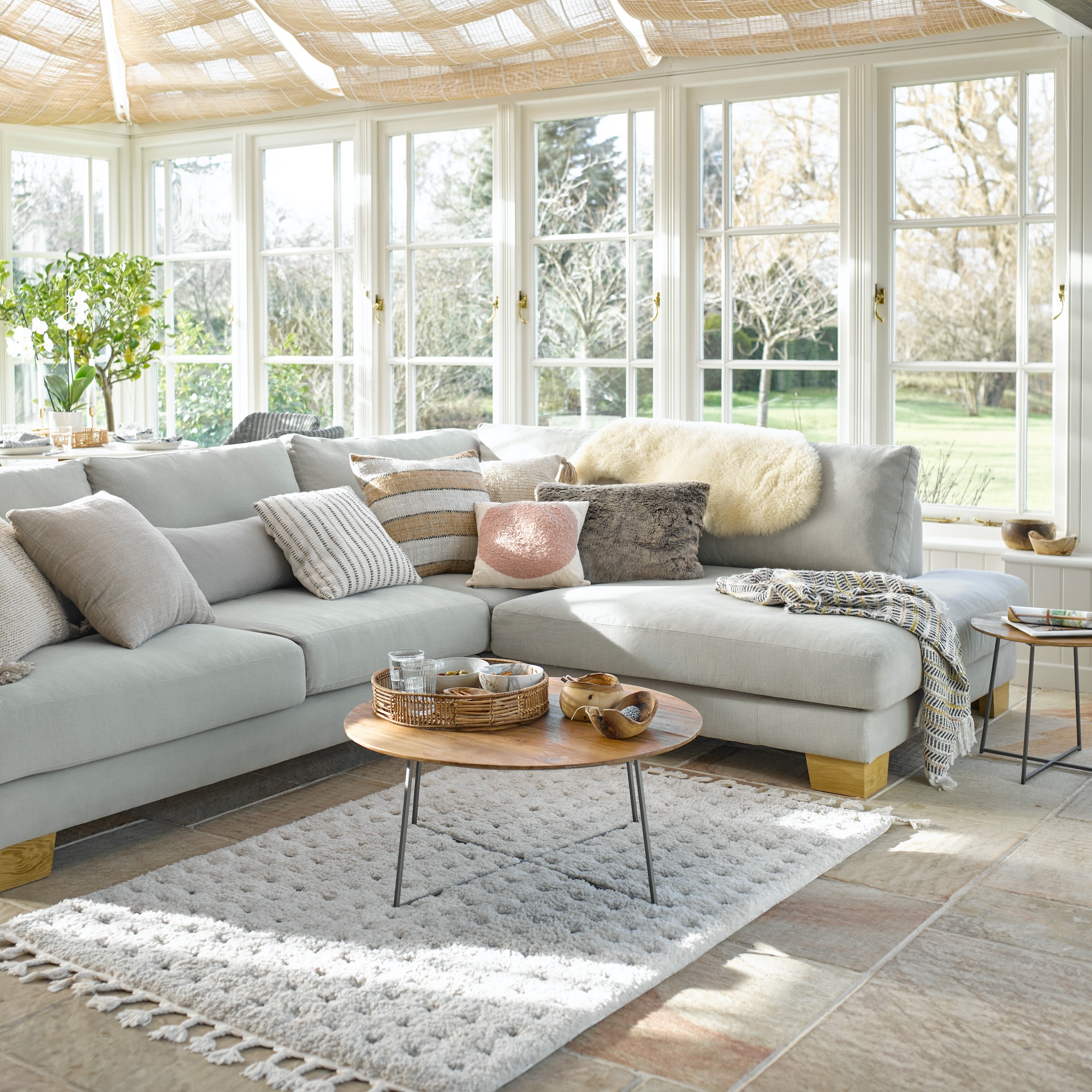 Garden room with ceiling blinds and grey-blue sofa