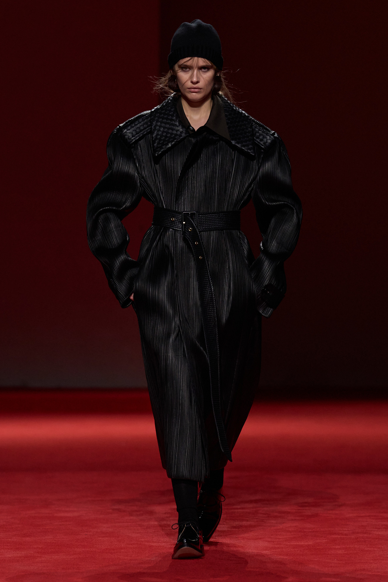 A model walking in the F/W 26 Bottega Veneta show during Milan Fashion Week wearing a pliss&amp;eacute; leather coat.