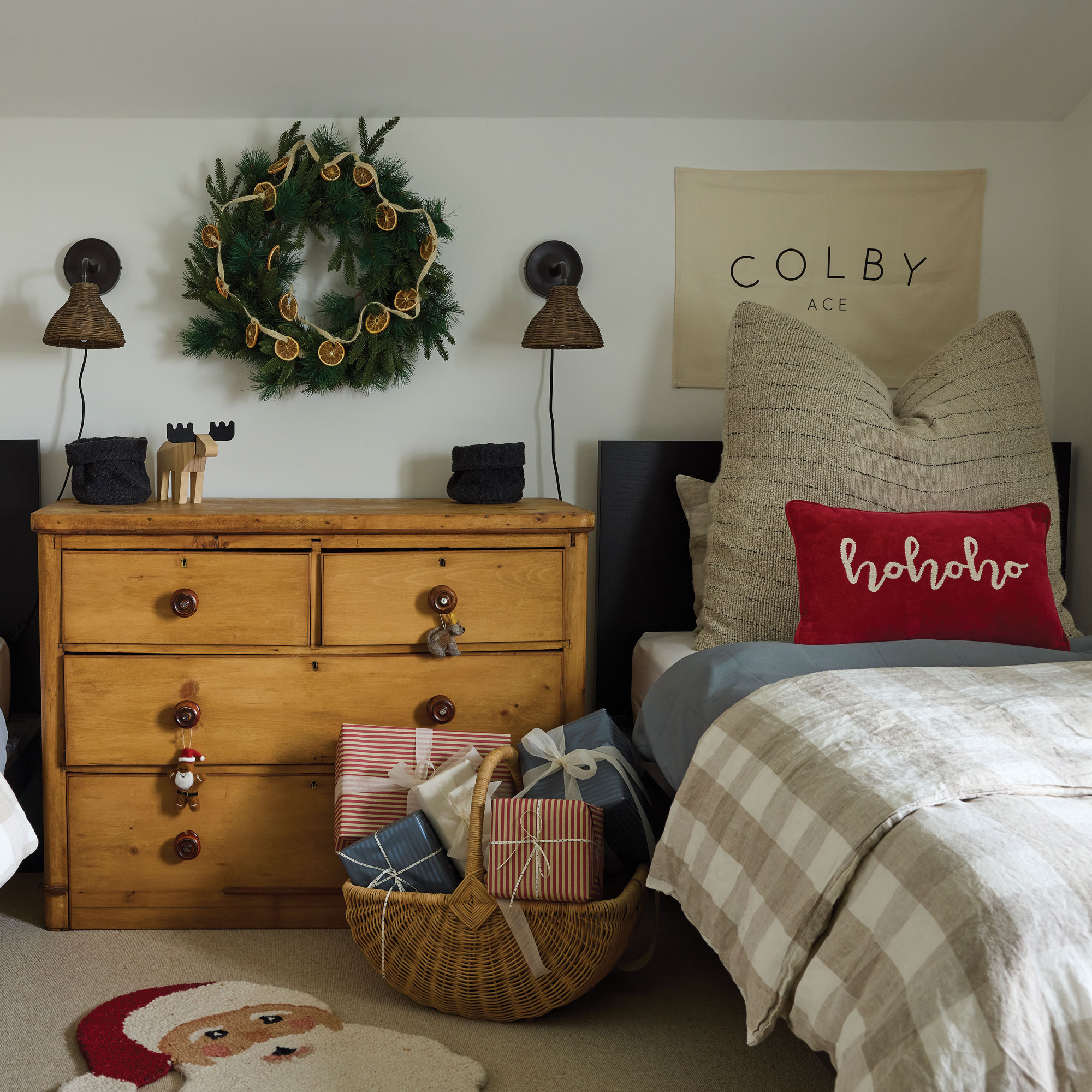Netural kids bedroom with a wooden chest of drawers, two wall lights and blue twin beds