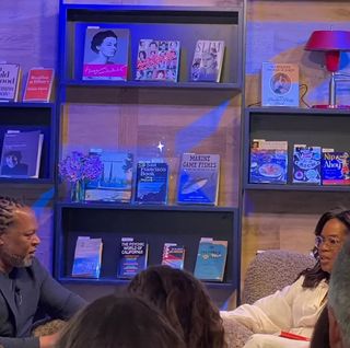 Author Shaka Senghor speaking with Oprah Winfrey at the grand opening of Godmothers bookstore in California.