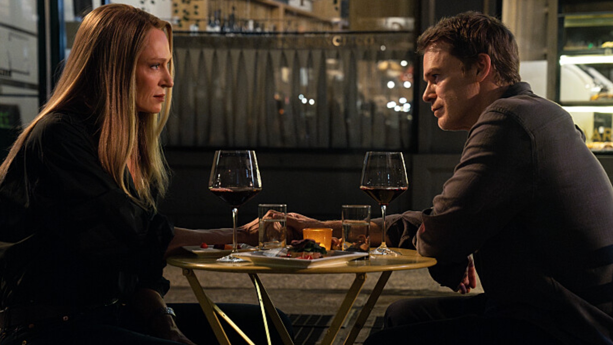 Dexter and Charley hold hands at dinner