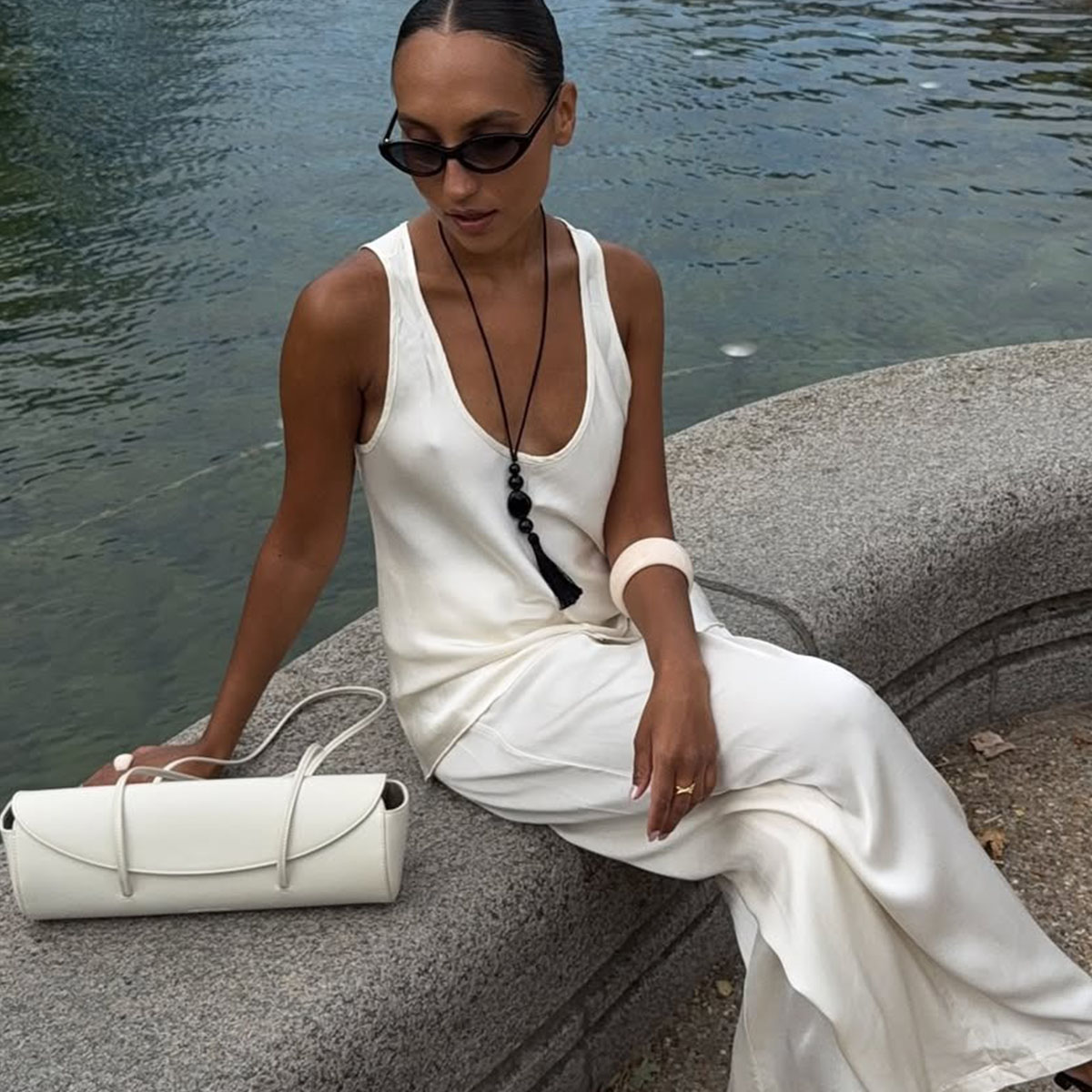 Woman in a satin top and long pendant necklace