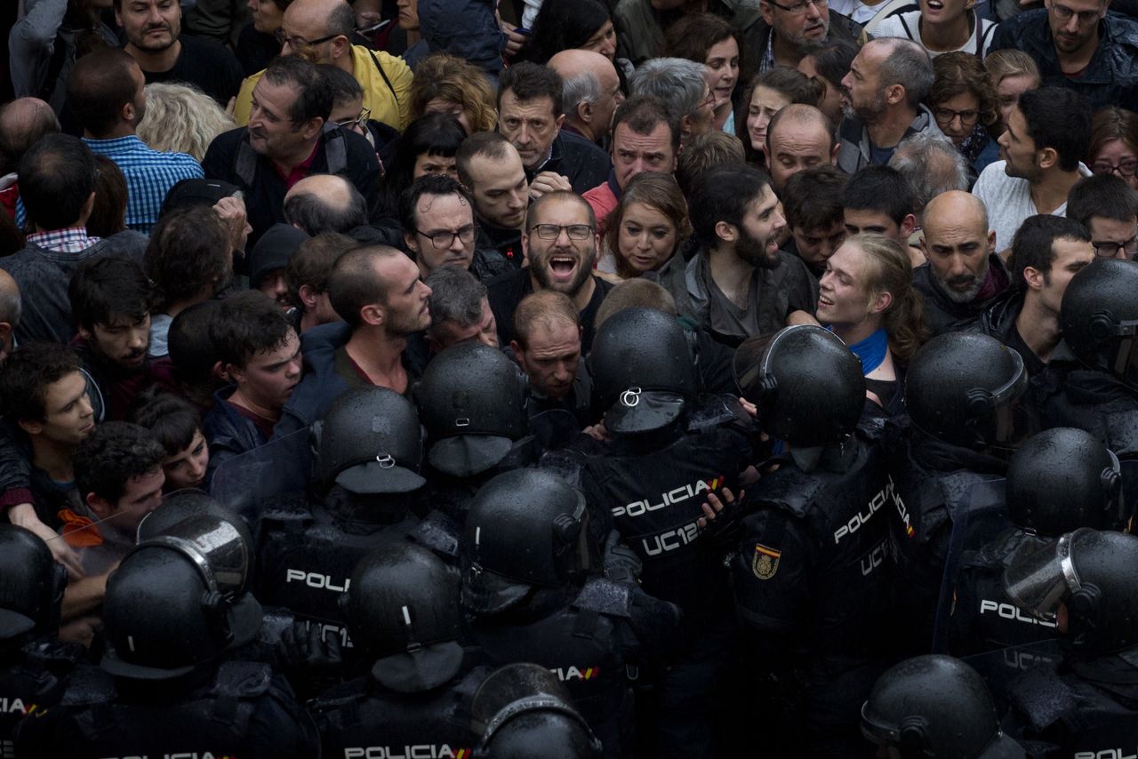 Spanish National Police block people trying to reach a voting site in Barcelona.