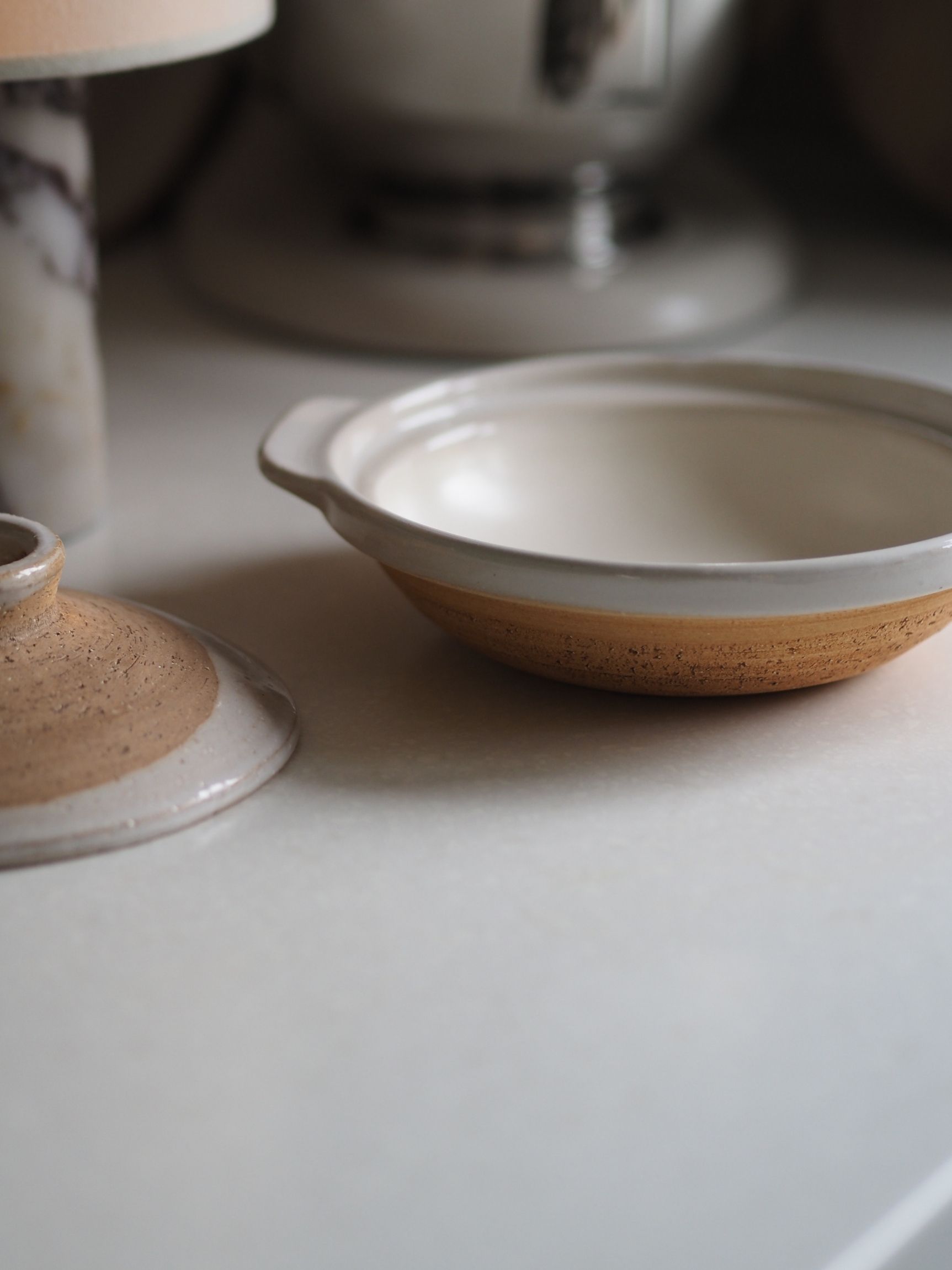a japanese donabe with decorative glazes in a neutral kitchen