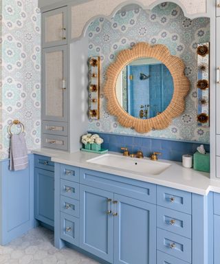 bathroom with pale blue cabinets and blue patterned wallpaper