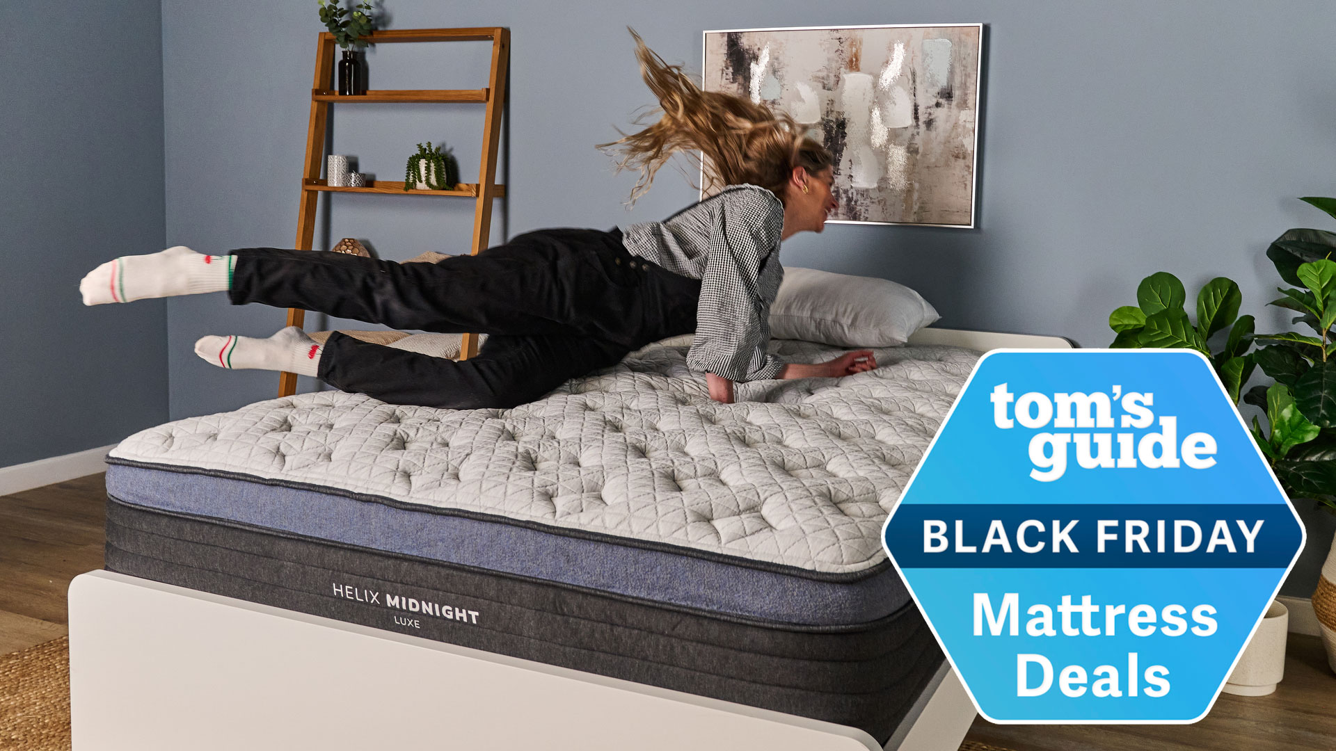 The Tom&#039;s Guide Sleep Editor jumping on a Helix mattress with a Tom&#039;s Guide Black Friday Mattress Deals badge overlaid