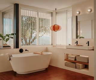 A white and wood bathroom with a curved bathtub and organic shapes and materials