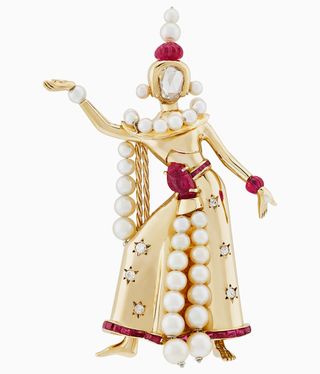 A gold statuette figure decorated with pearls, diamonds and red gemstones.