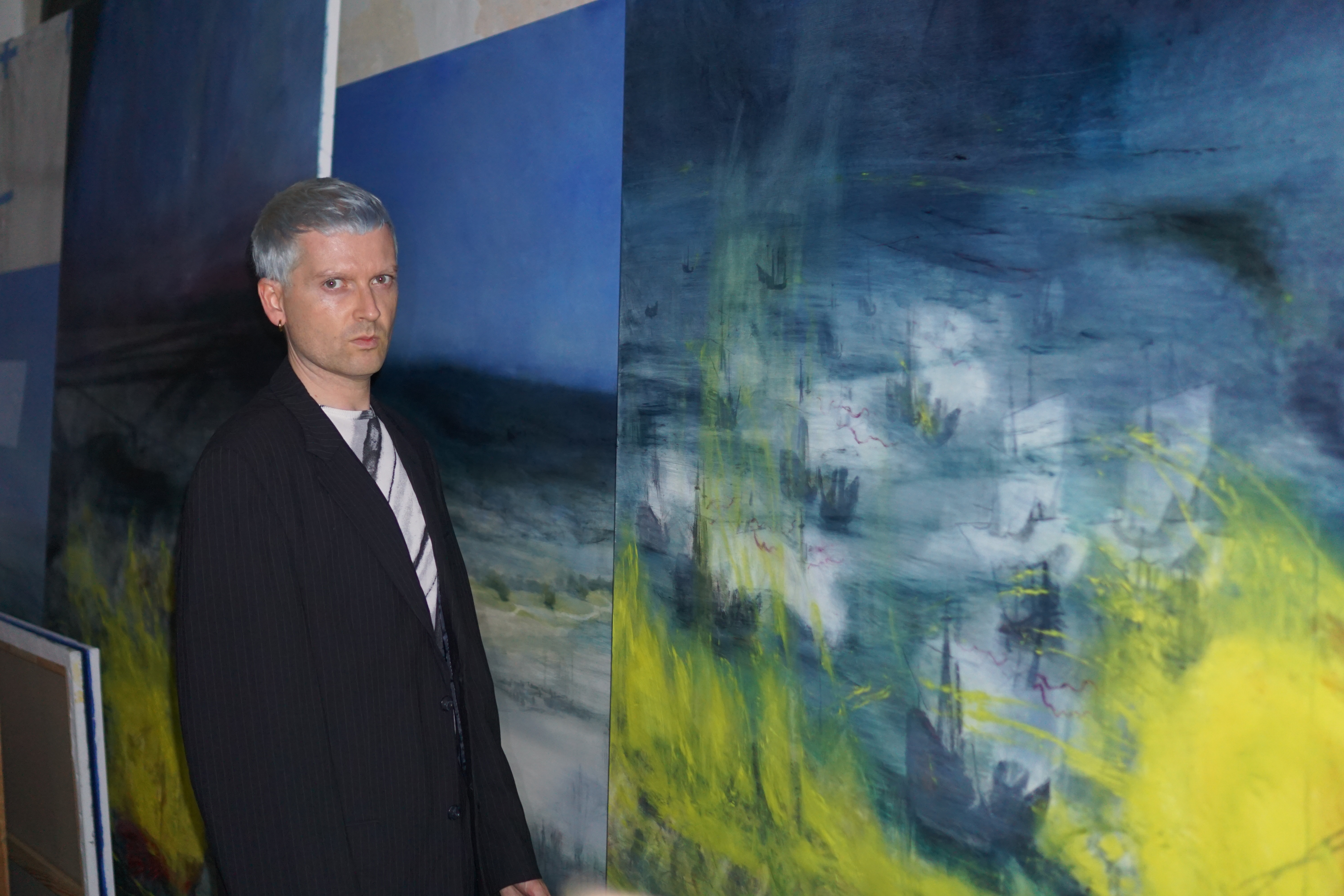 man in suit in front of artwork