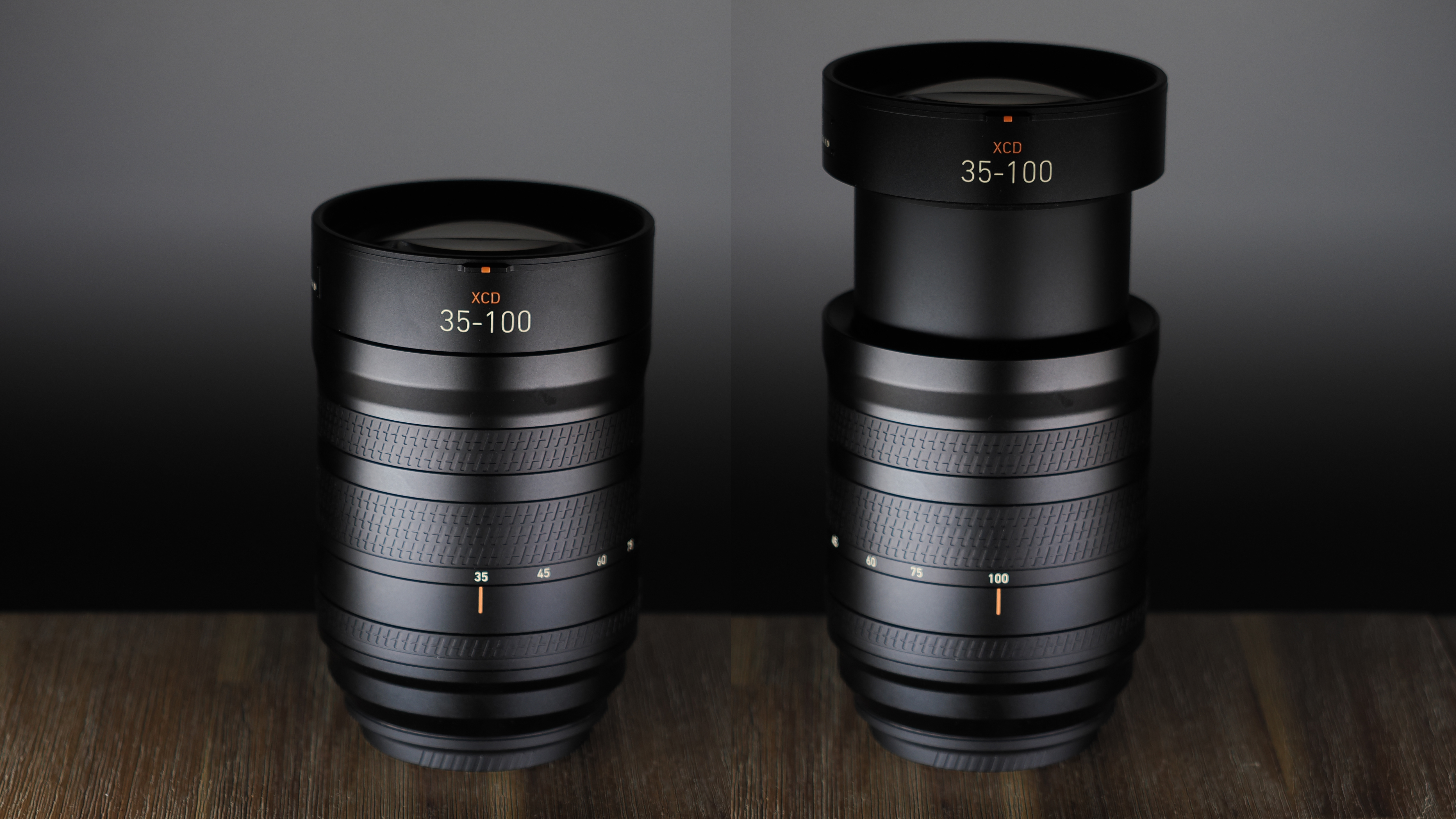 Hasselblad XCD 35-100E lens on a wooden surface in a moodily lit environment