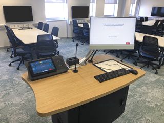 A teacher's lectern with Extron hardware like a control tablet and switched for collaborative learning.
