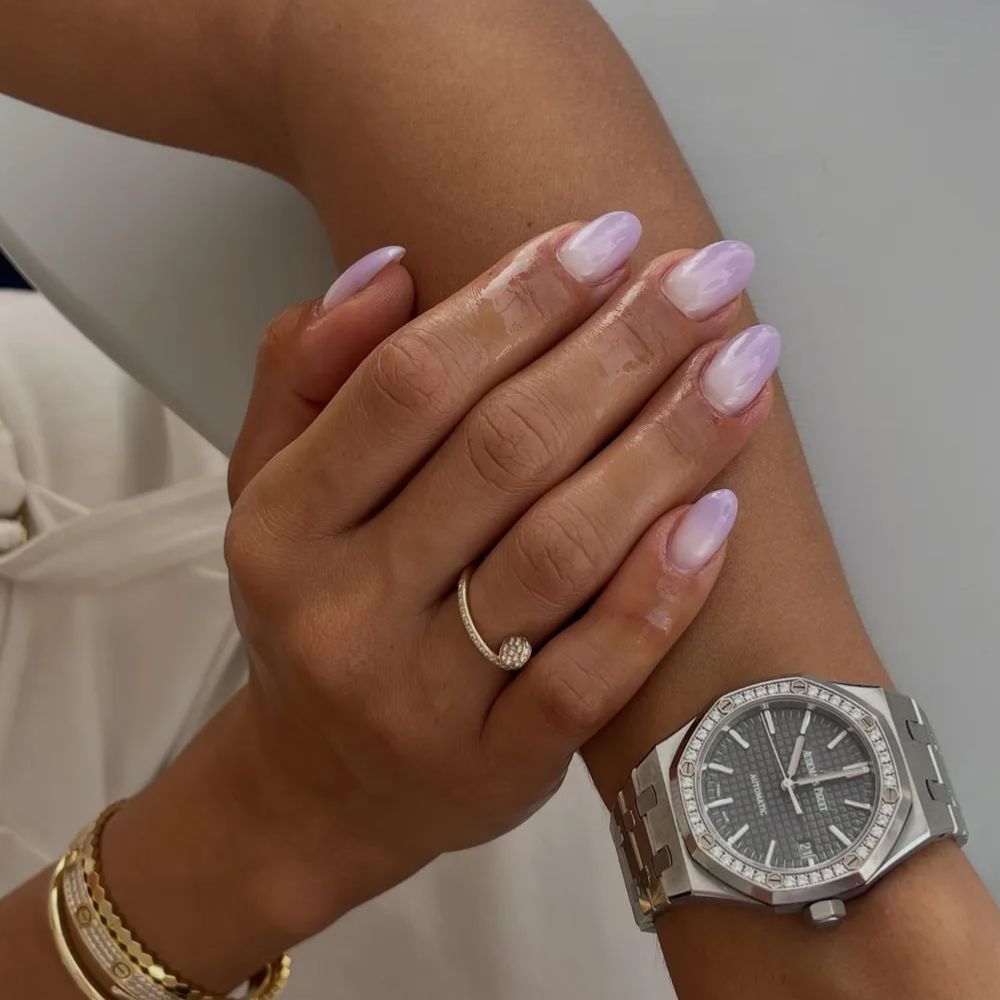 A woman with a purple ombr&eacute; manicure