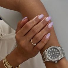 A woman with a purple ombr&eacute; manicure