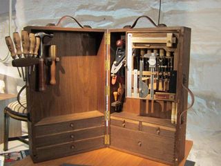 A light brown vertical wooden toolbox