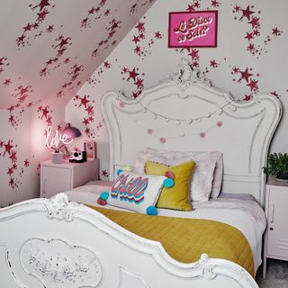 vintage style bed in bedroom with red and white patterned wallpaper