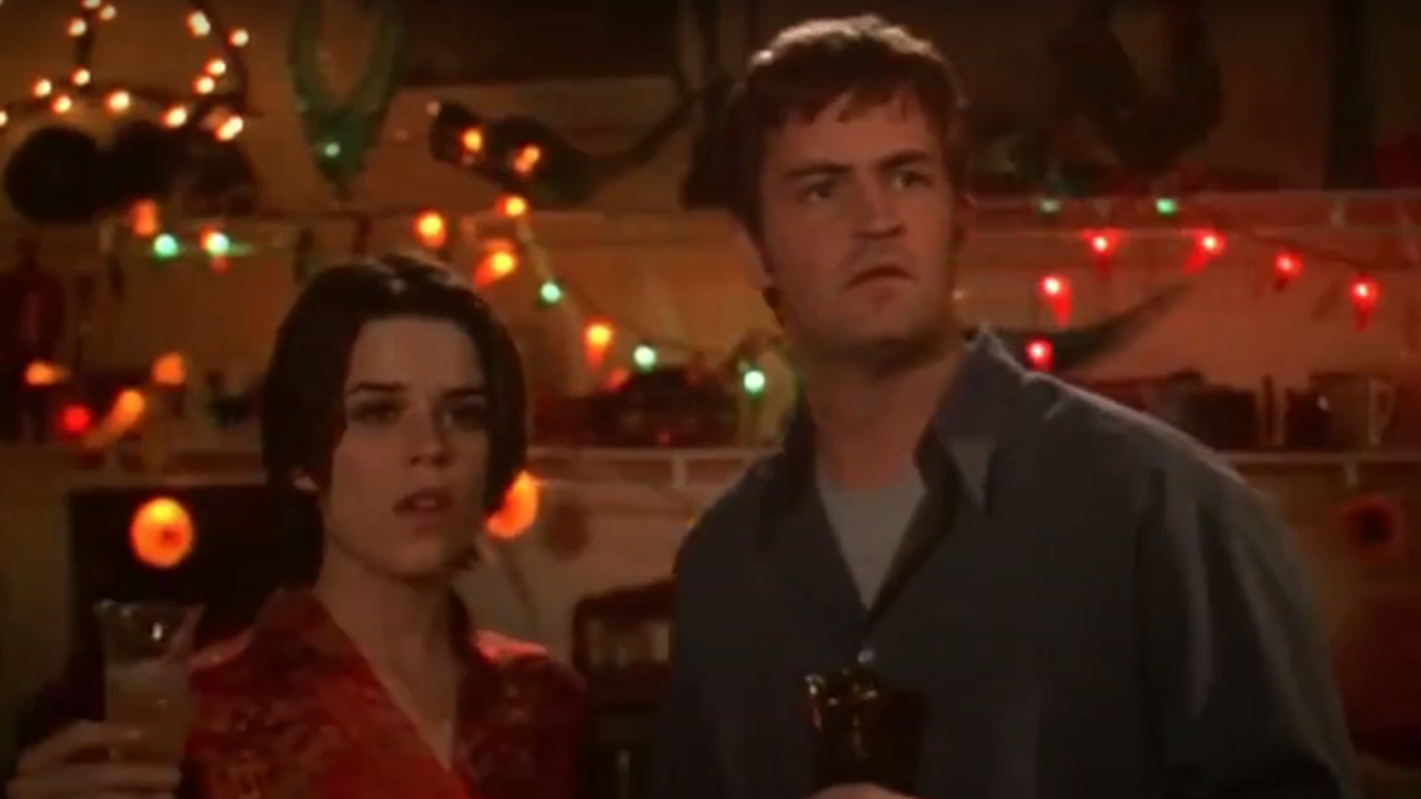 Neve Campbell and Matthew Perry looking shocked while holding drinks in Three To Tango.