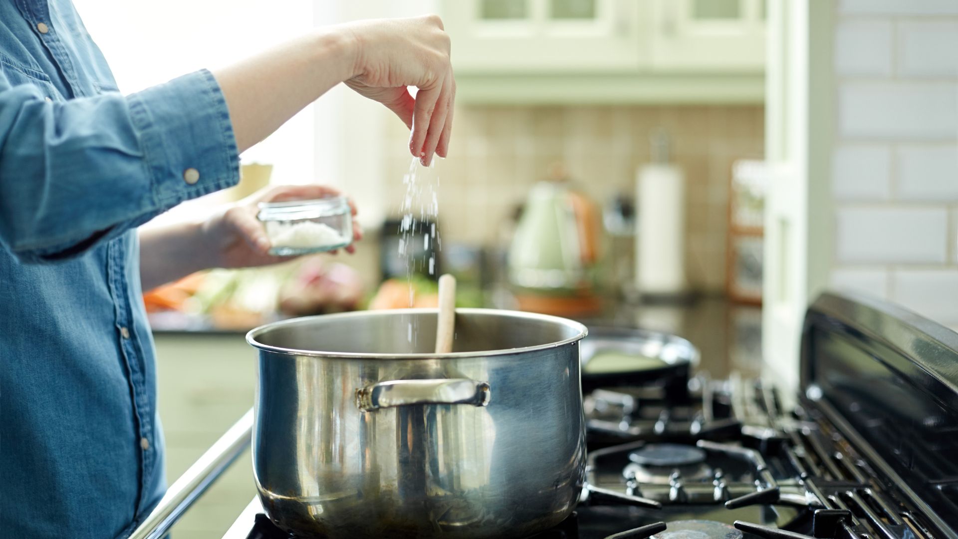 Woman seasoning a pot of pasta