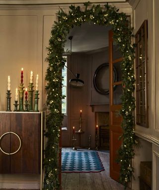 Garland over doorway, candles, console table, string lights