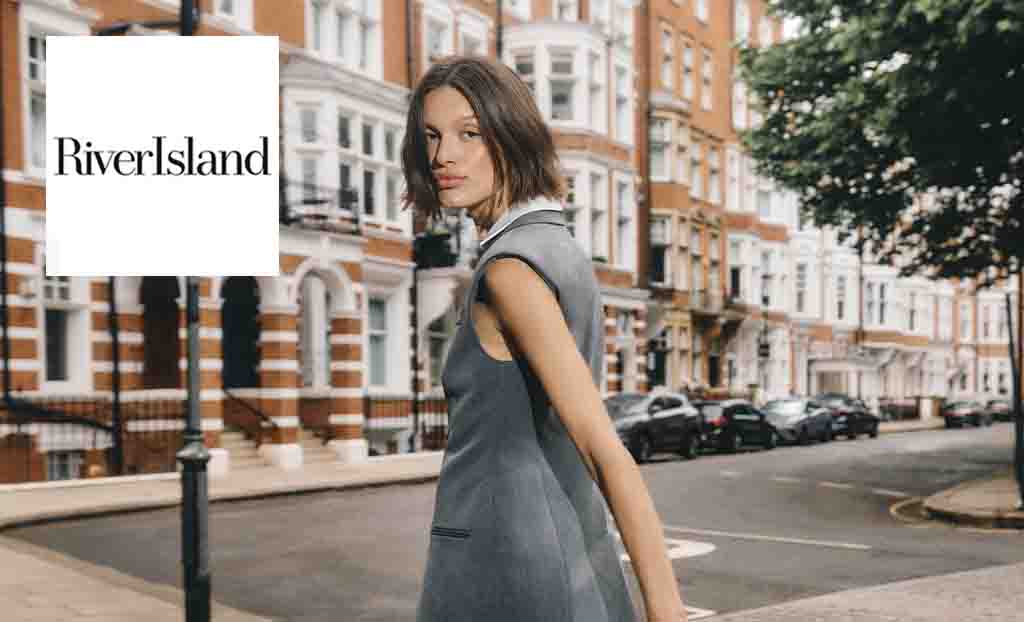 RIver Island logo placed over a woman posing with grey outfit in the streets of london