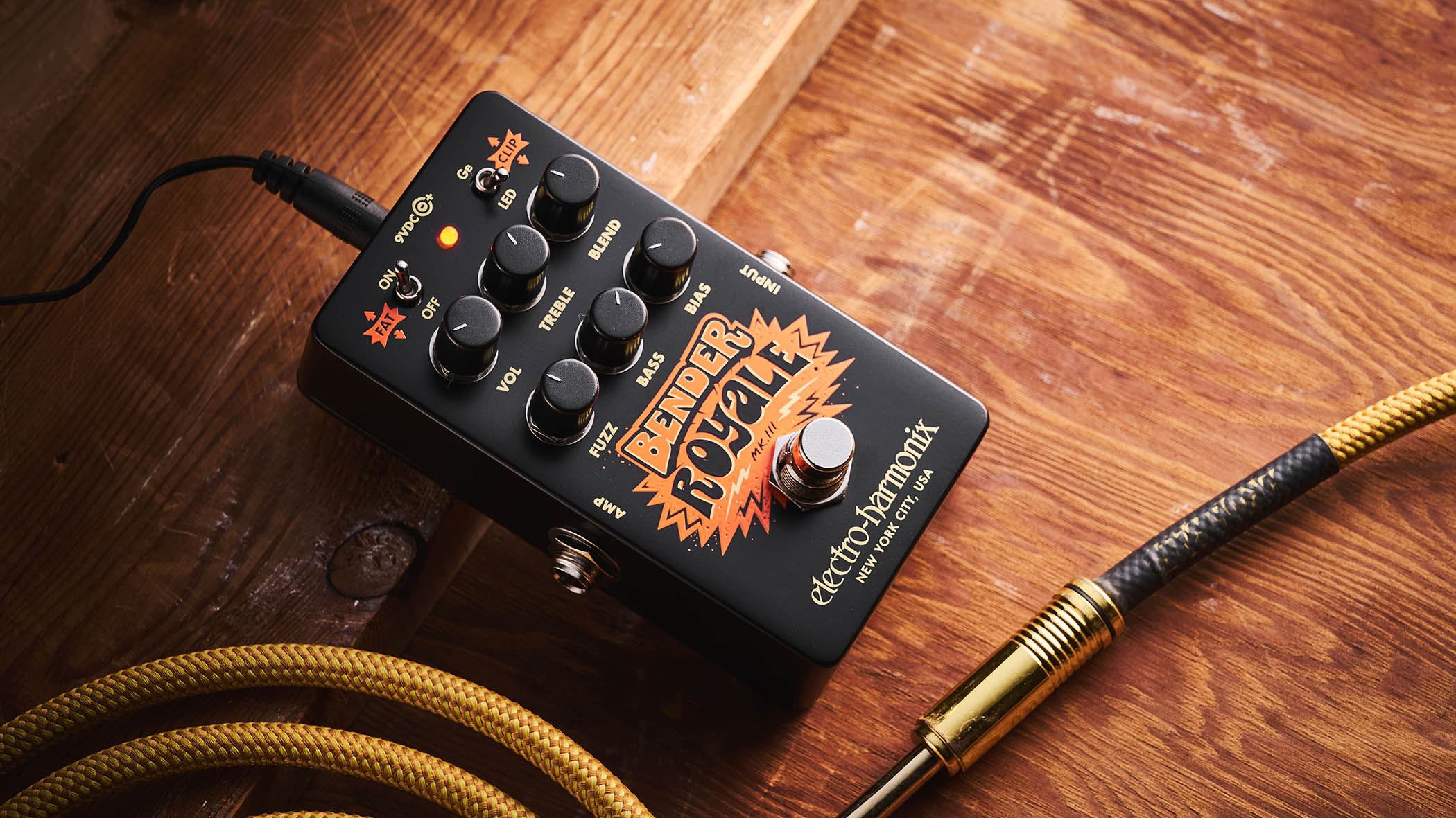 Electro-Harmonix Bender Royale &ndash; the feature-packed fuzz pedal is finished in a black enclosure with orange graphics/text, and is photographed here in warm tones against a wooden background.