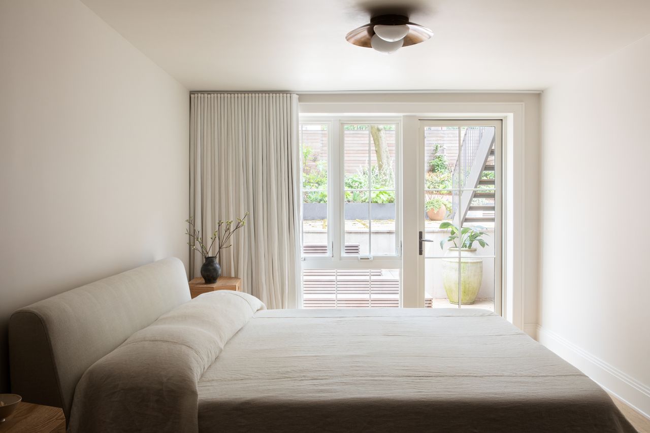 A bedroom with a beige cotton quilt