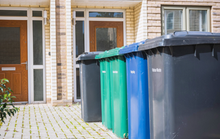 Bins lined up outside two front doors