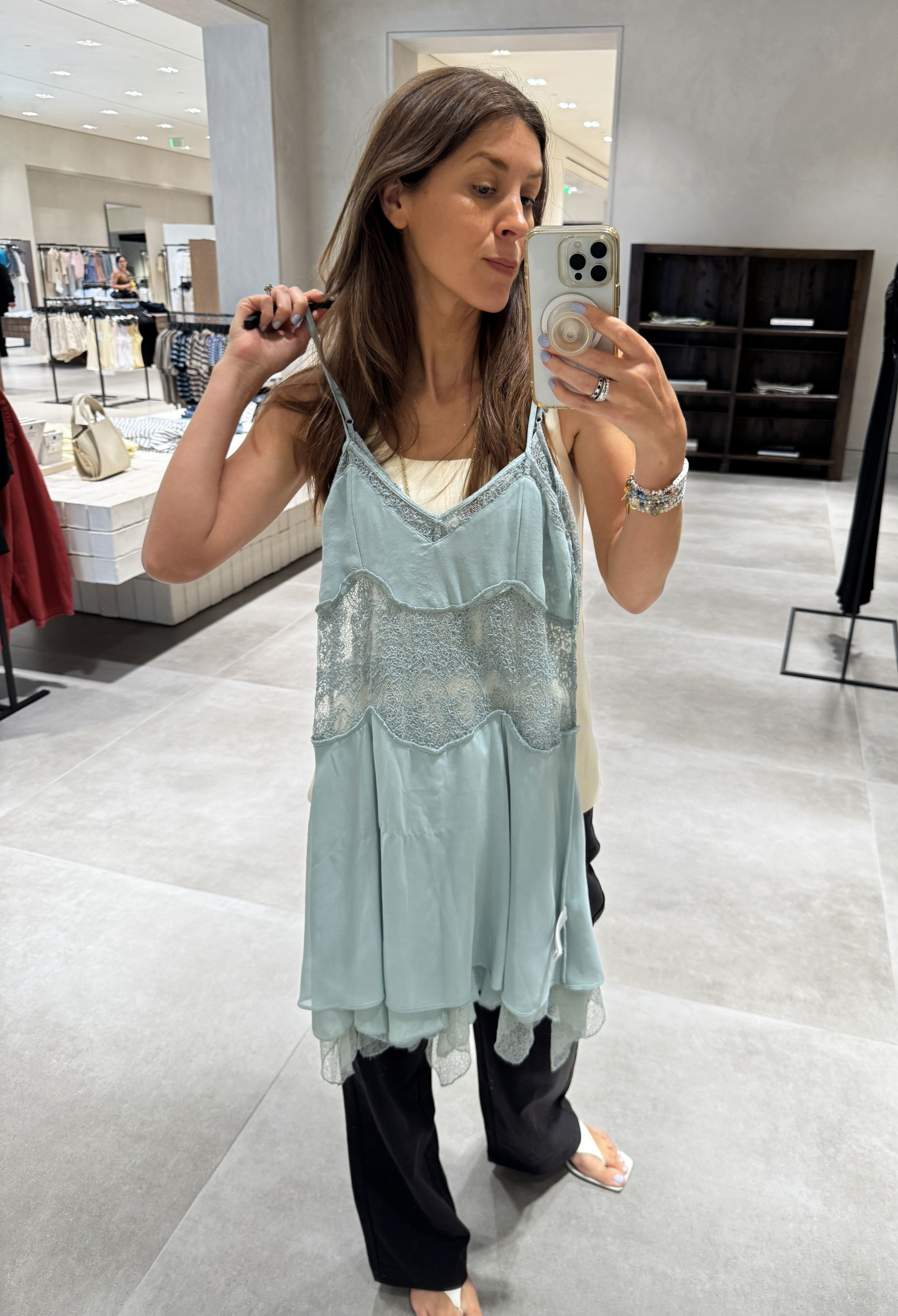Woman holding up a mint green Zara dress
