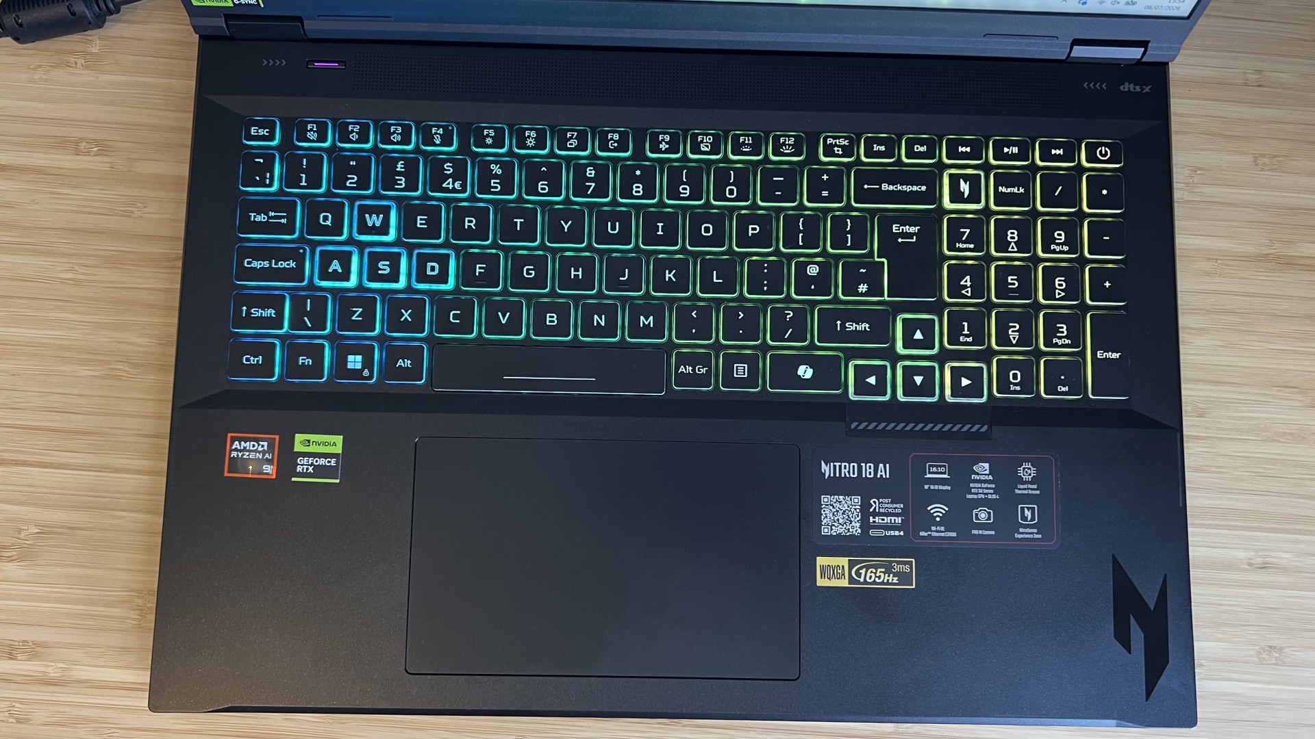 Top down view of Acer Nitro 18 AI gaming laptop keyboard on a wooden desk