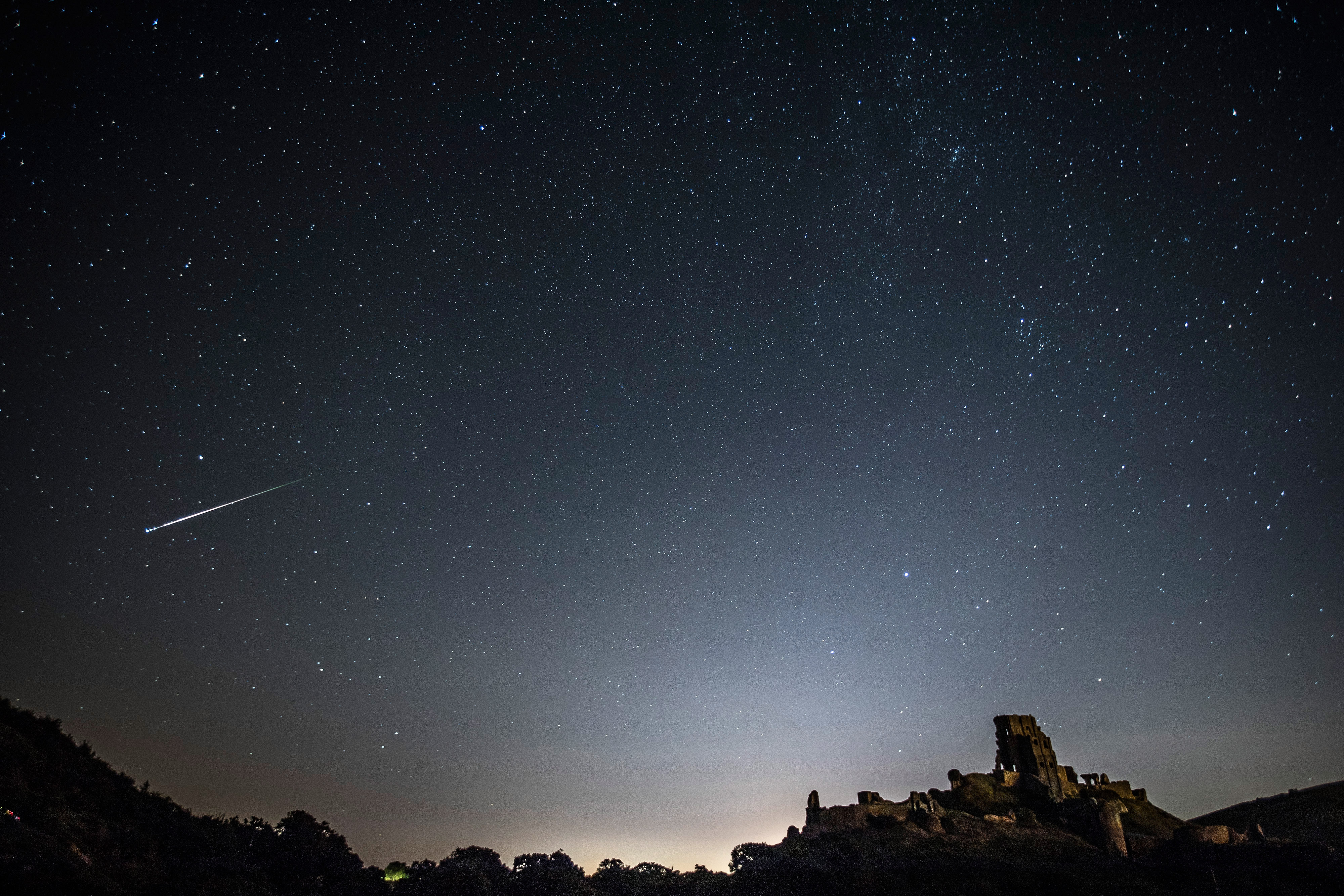 A Perseid Meteor flashes across the night sky above Corfe Castle on August 12, 2016 in Corfe Castle, United Kingdom. 