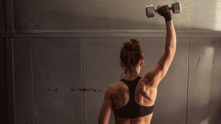 a photo of a woman doing a single arm clean and press
