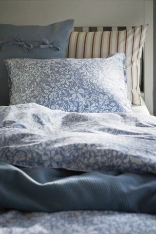 A bedroom with blue printed bedding